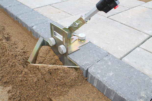 Quick-E-Sand Plow pulls the sand away from the paver edge to create the perfect setting bed for edging